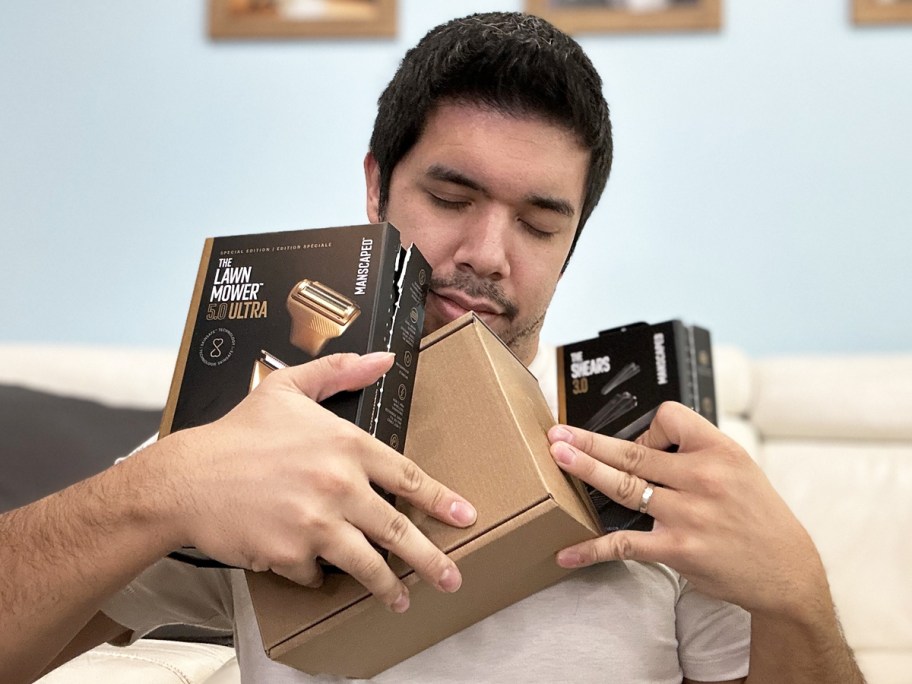 man hugging boxes of Manscaped products