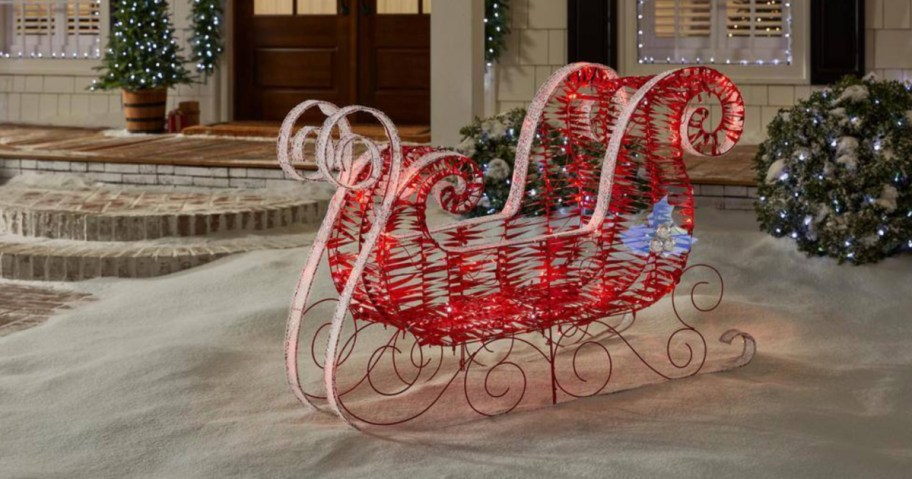 Red metal sleigh outside home in winter time