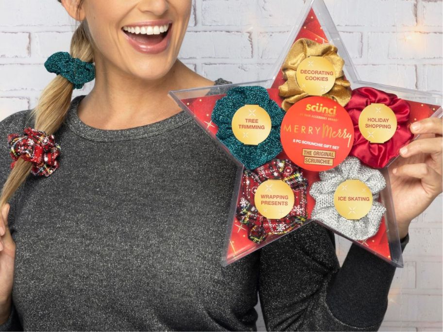 woman holding a 5-pack of holiday Scunci scrunchies