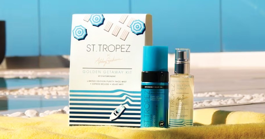 st tropez tanning products on towel near pool