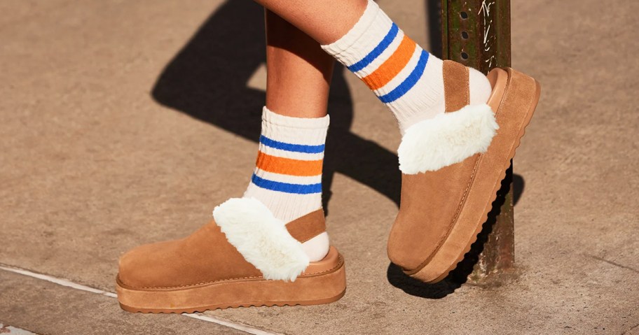 woman wearing a pair of tan platform clogs with white crew socks