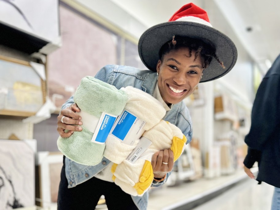 woman holding up 3 blankets in target store