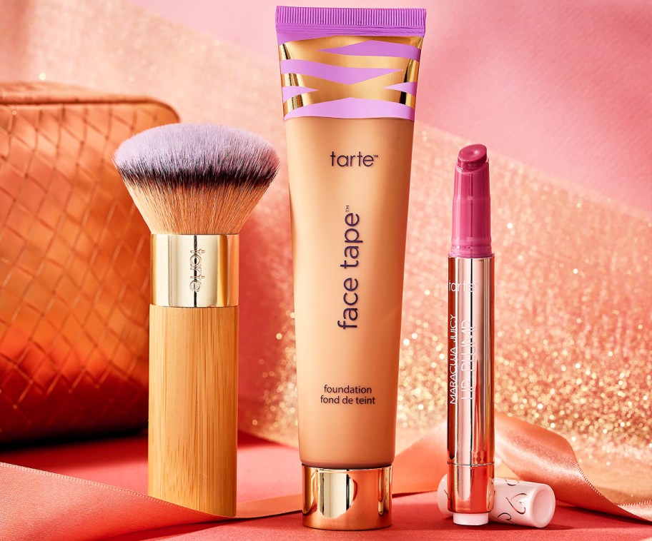 tarte face tape, lipstick, and brush with bag in background