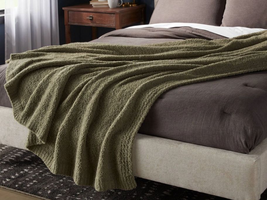 a green blanket draped across a bed