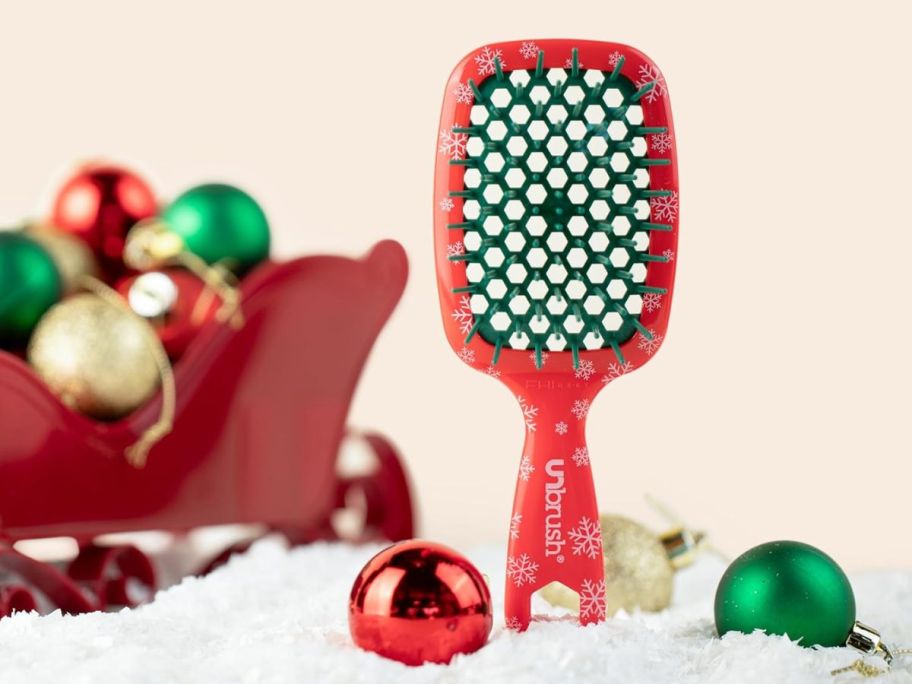 An UNbrush Mini holiday brush next to holidayc decorations