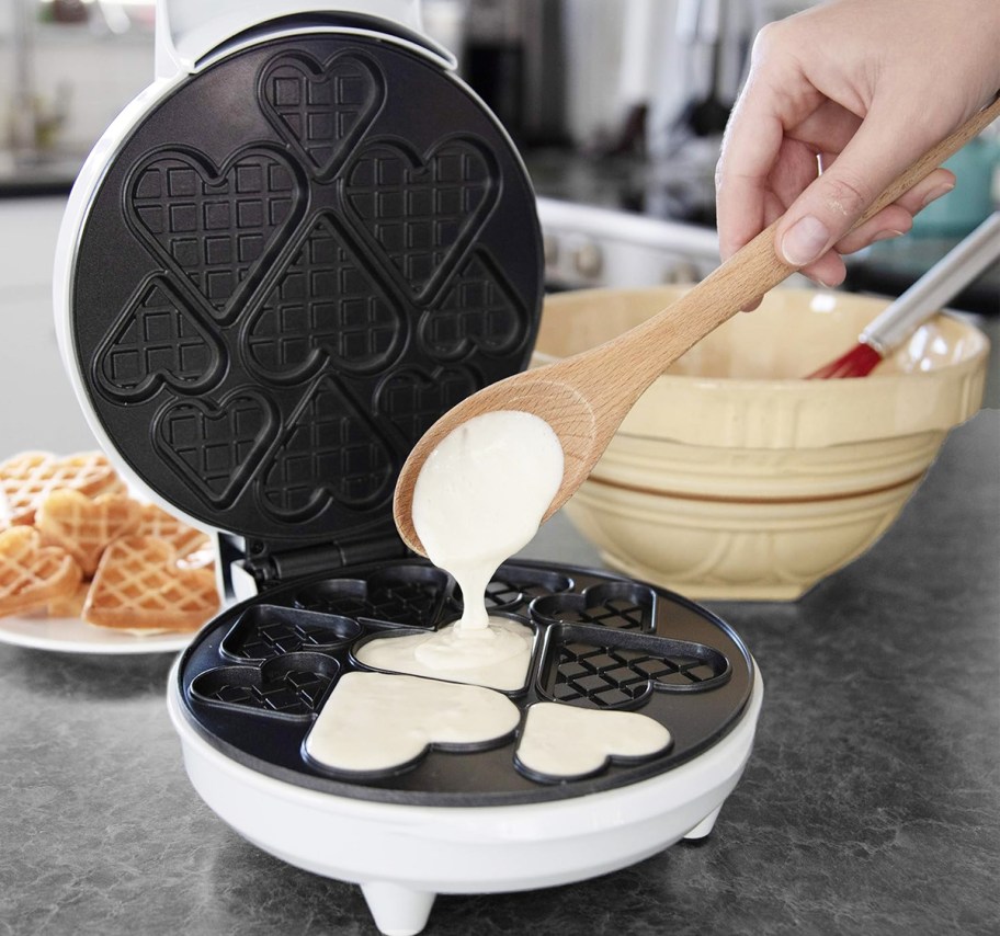 pouring batter into a heart shaped waffle maker