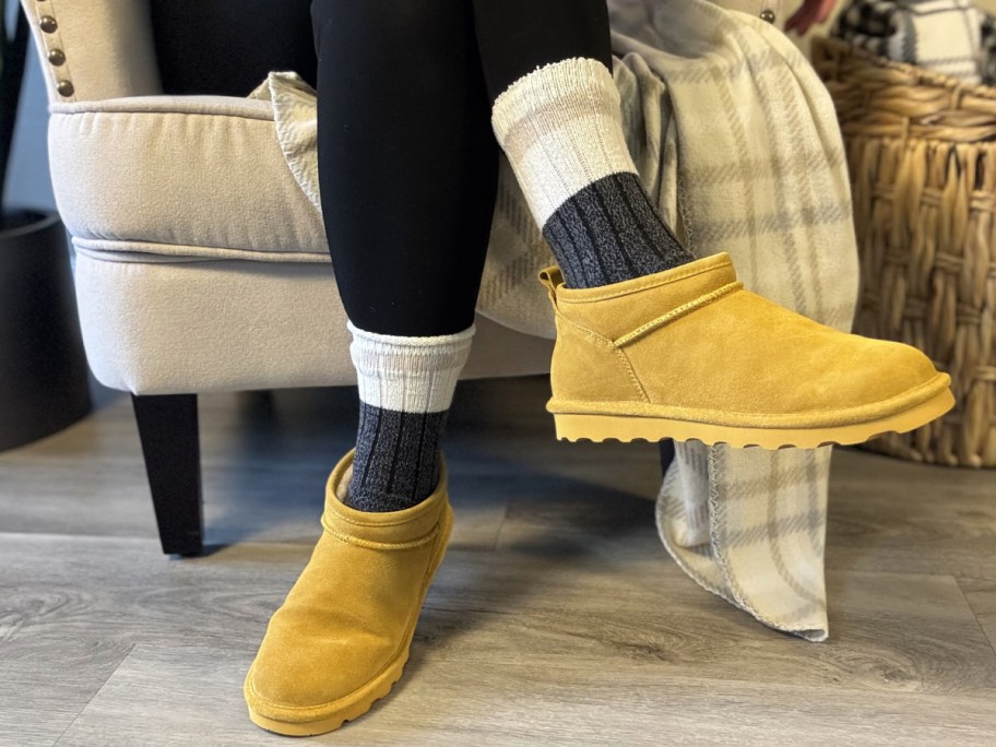 Woman wearing mustard color boots on her feet with socks