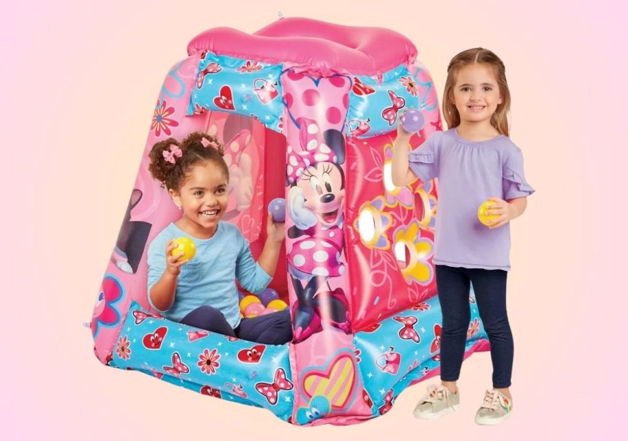 two little girls with a minnie mouse inflatable ball pit 