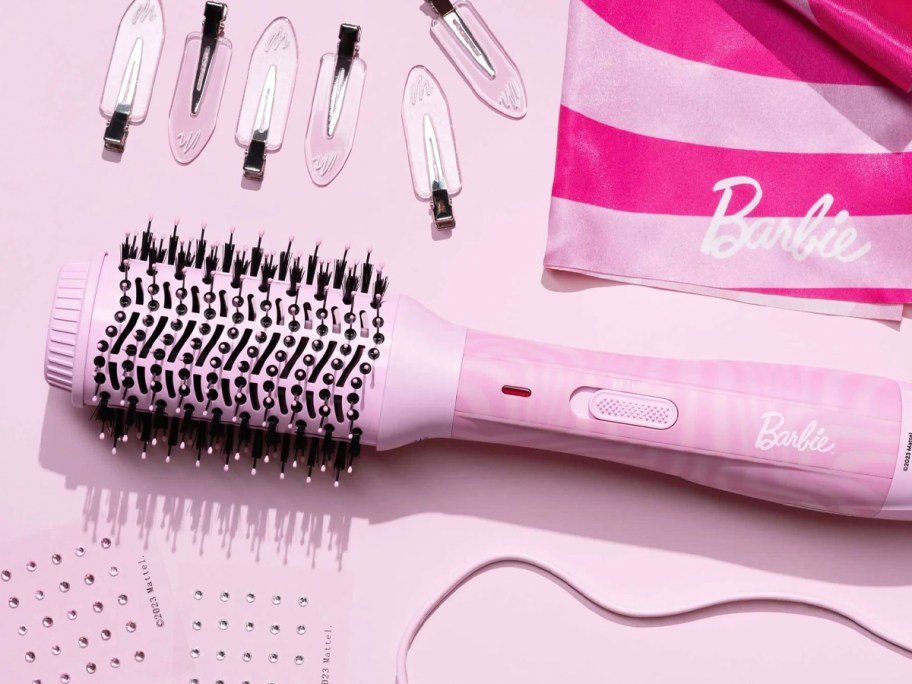 pink barbie blow dryer with accessories on table