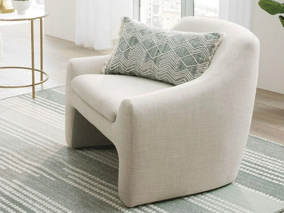 beige accent chair on blue striped rug