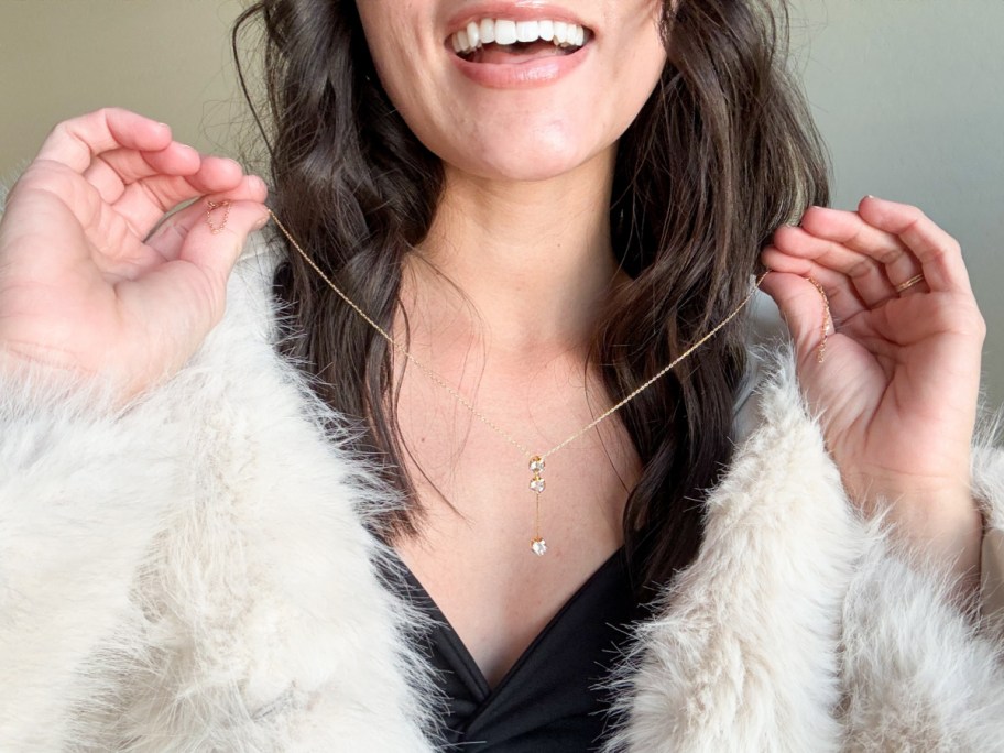 woman in fur coat holding necklace around neck