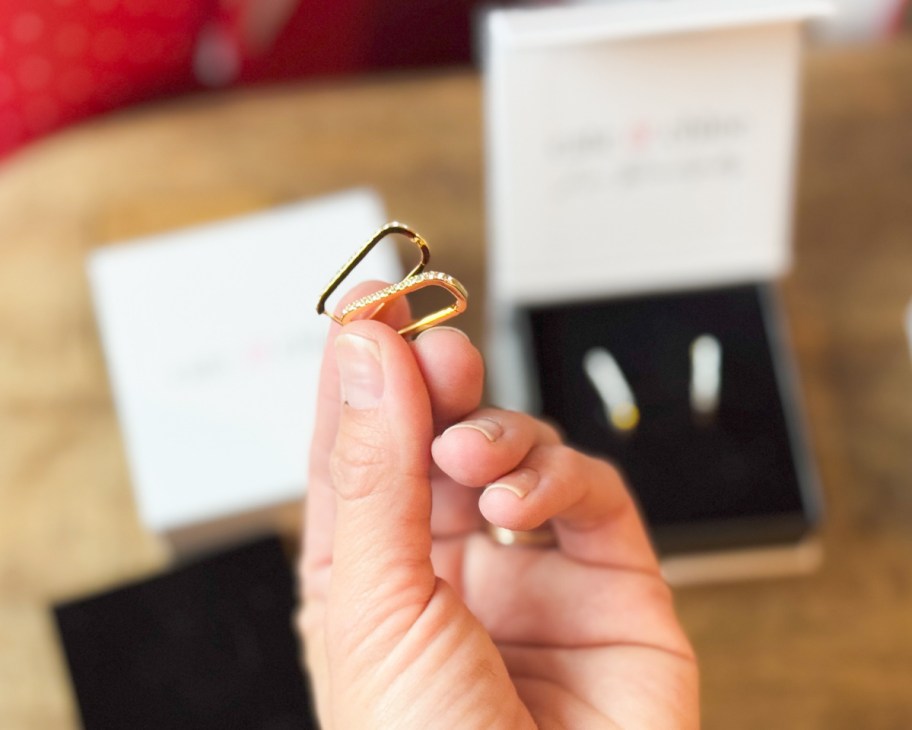 hands holding square hoop earrings