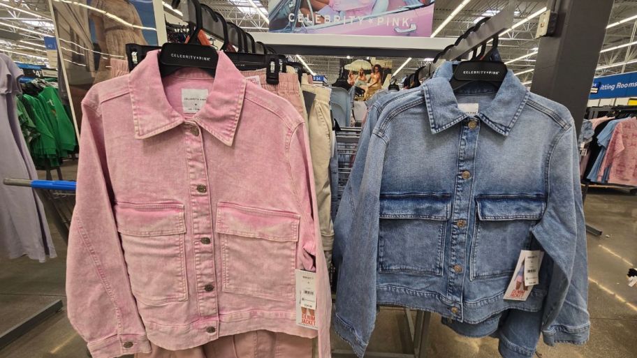 pink and medium wash denim jackets hanging on a clothing rack in a store