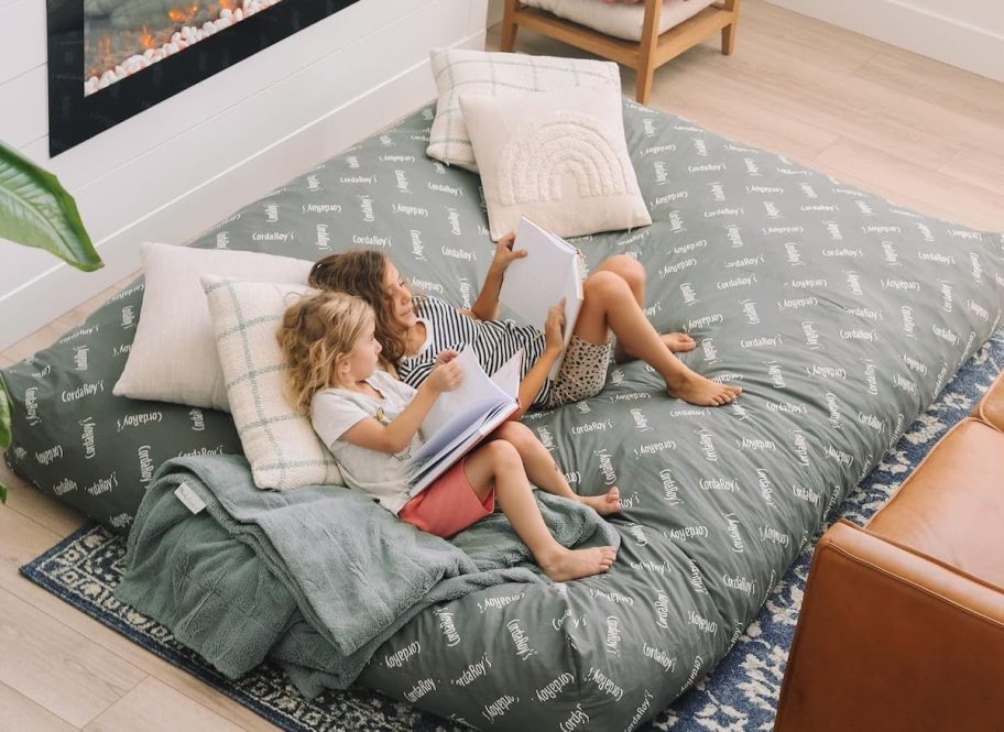 girl lounging on cordaroy bed on floor with throw pillows