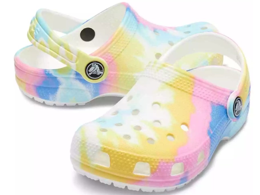 a pair of kids Crocs clogs in a pink, blue, and yellow tie dye print