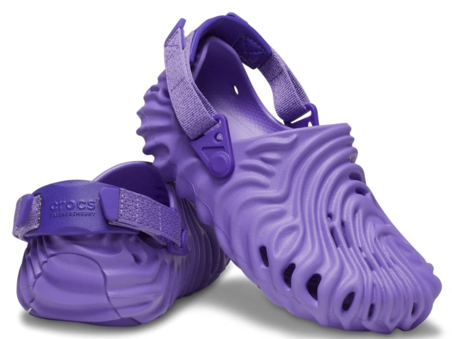 a pair of kids purple Crocs clogs in a wavy type pattern