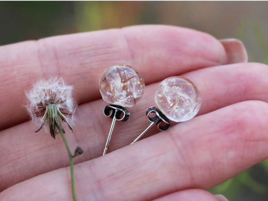dandelion seeds in stud earrings in hand