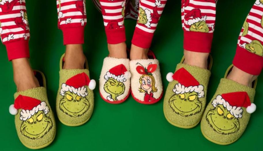 a family of 3 wearing grinch slide slippers