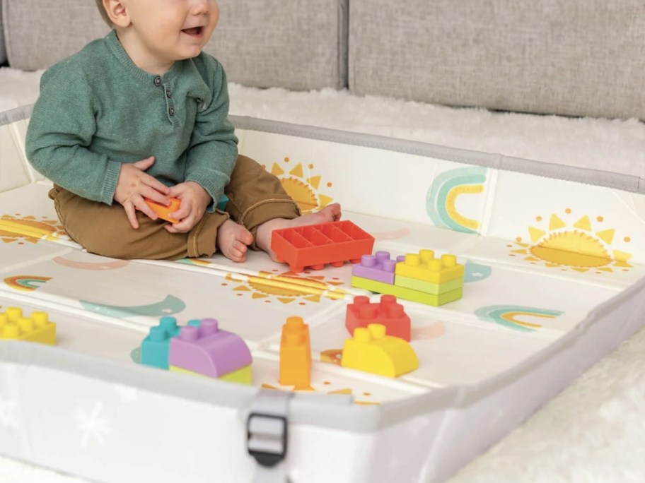 baby playing in playmat with blocks