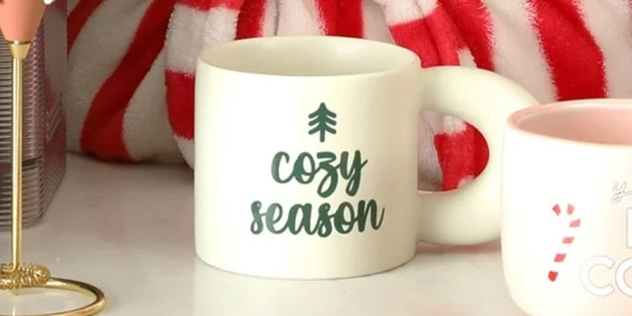 cozy season white mug on table