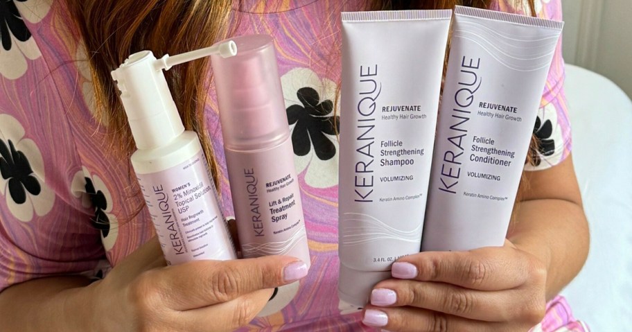 woman holding bottles of keranique hair care