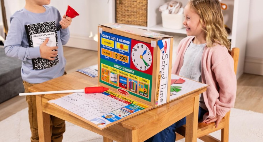 kid playing with school set