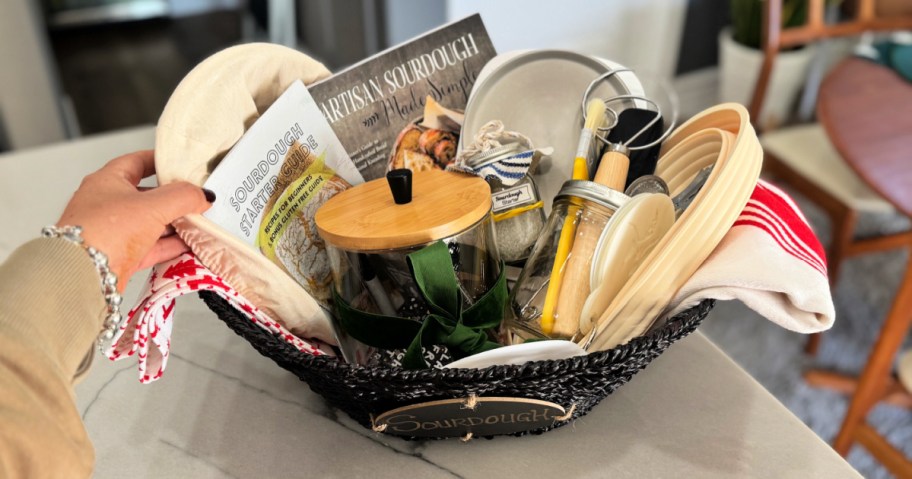 placing items in a gift basket with sourdough bread baking supplies