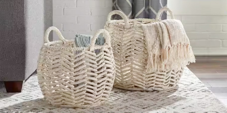 two white storage baskets with blankets inside