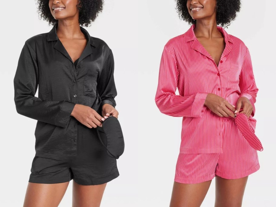 2 women wearing long sleeve button up pajama tops and matching shorts, one set is solid black and one is pink and red stripes