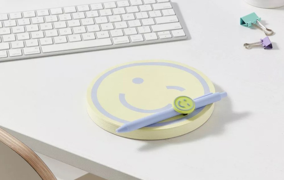 smiley notepad and pen set on onlineputer desk