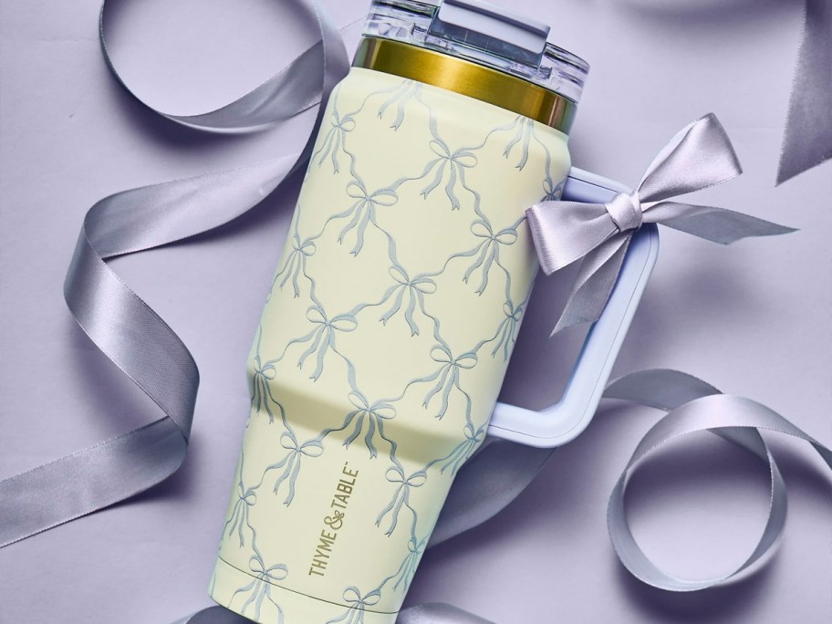 purple and white bow tumbler laying 