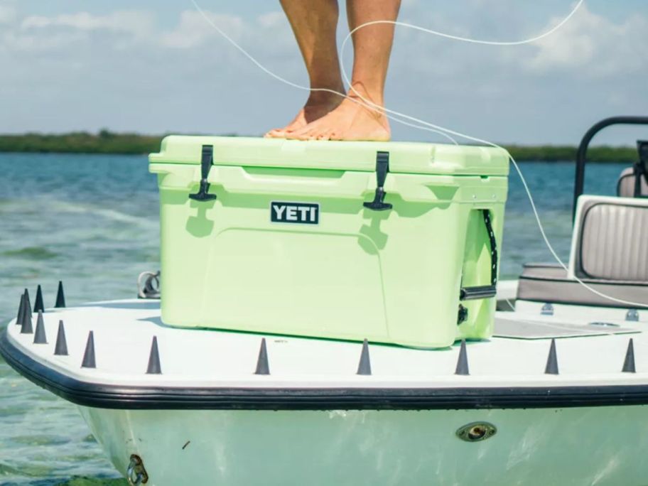 person standing on key lime YETI Tundra 45 Cooler on boat