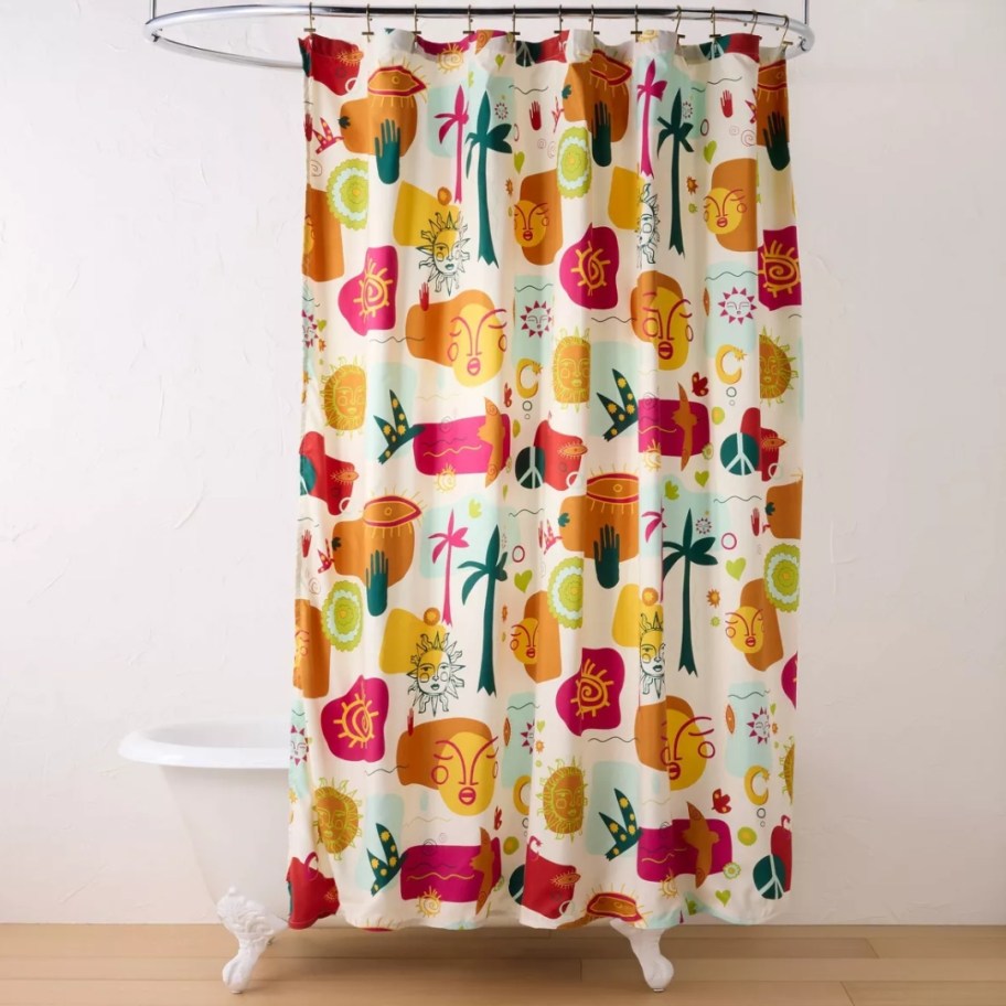 a multicolor collage style shower curtain hanging above a white bath tub