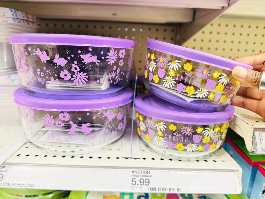 hand touching glass storage containers on store shelf