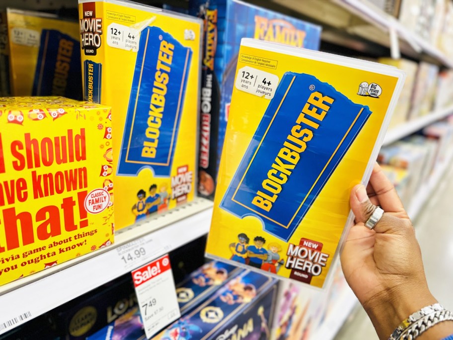 hand holding up Blockbuster The Game in front of store shelf