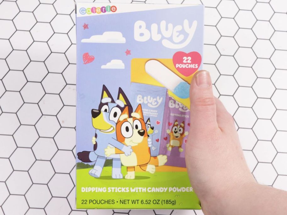 A hand holding a box of Bluey Classroom Exchange Kit w/ Dipping Sticks & Candy Powder 