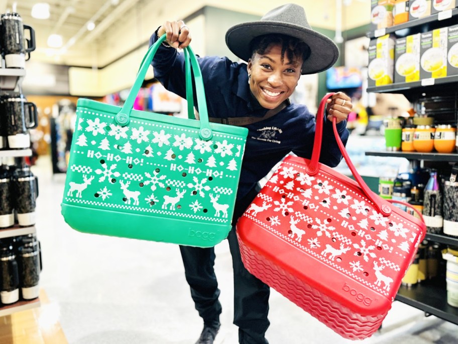 woman holding up green and red ugly sweater print bogg bags