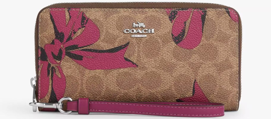 brown and red bow print coach wallet with wrist strap