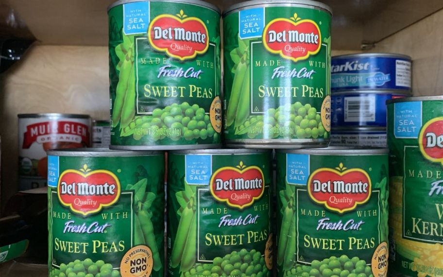 5 cans of del monte peas stacked on a pantry shelf