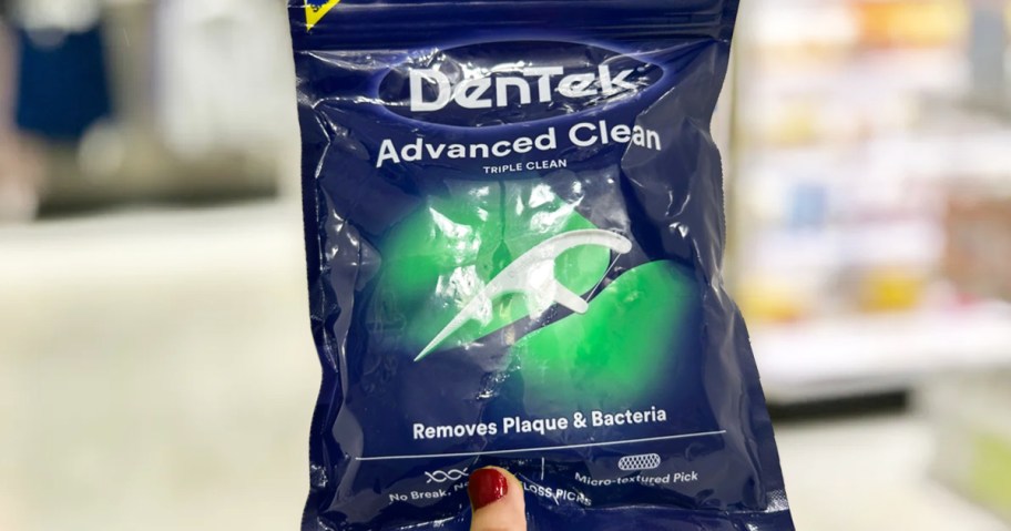 hand holding up pack of dentek floss picks in store