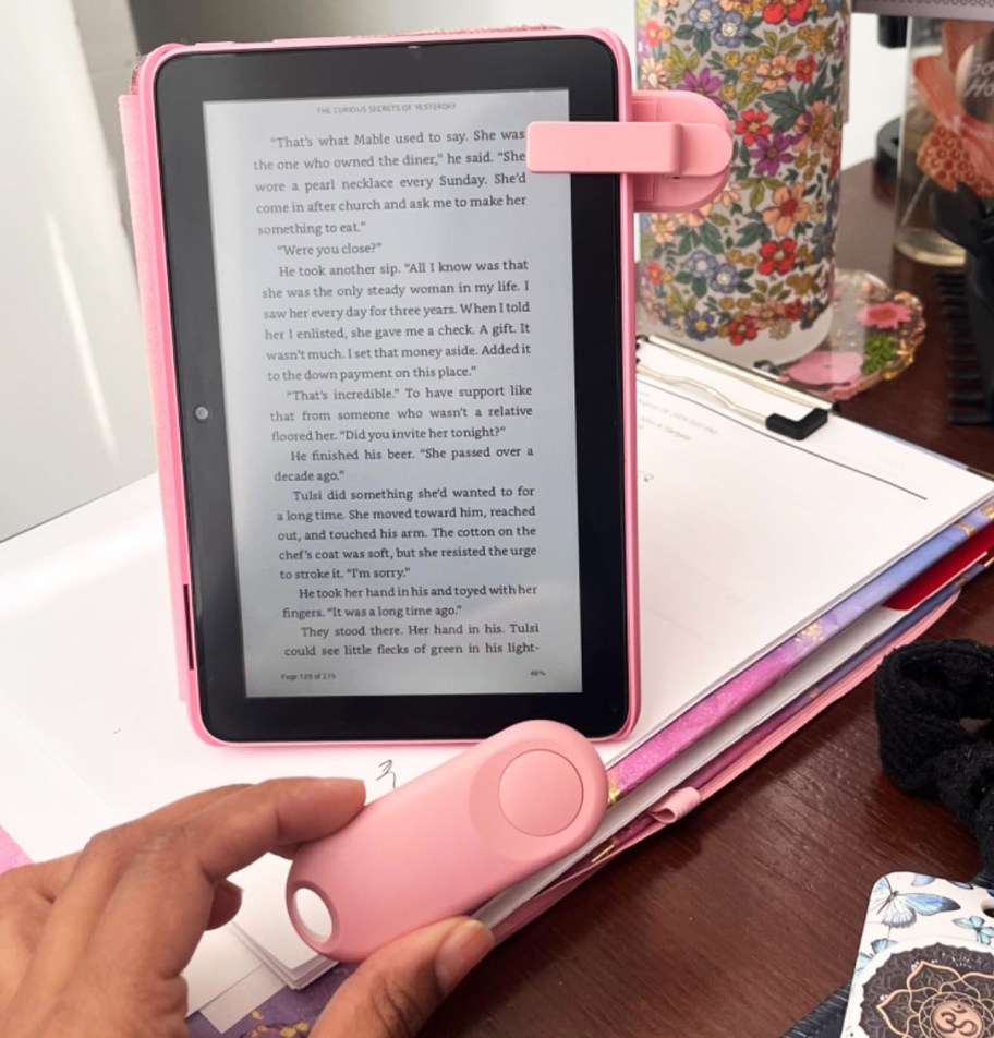 hand holding pink remote to e-reader page turner on her kindle