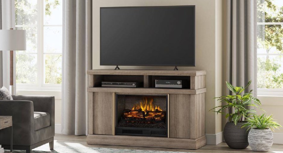 Electric fireplace console with tv displayed on top of it