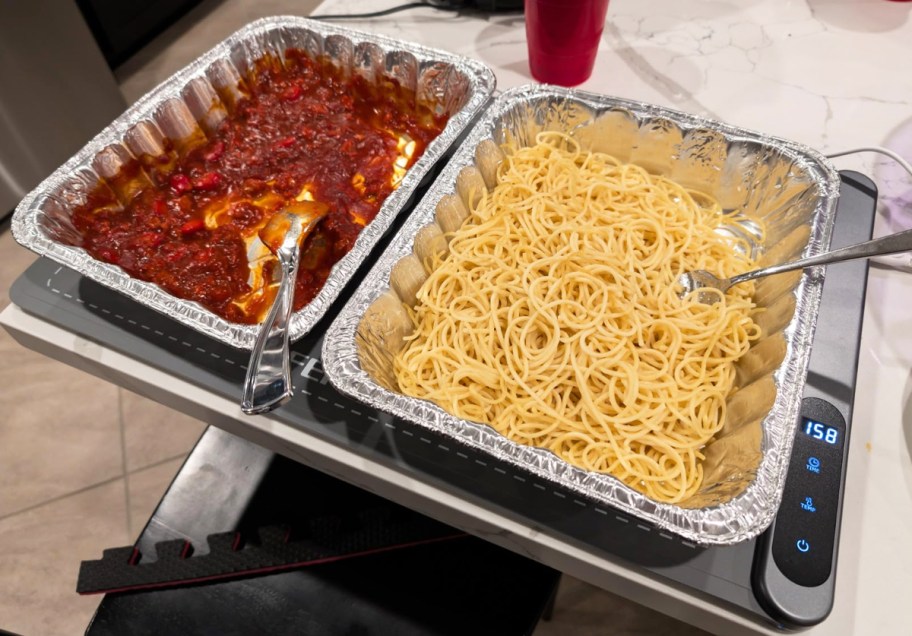 trays of spaghetti and red sauce on warming mat