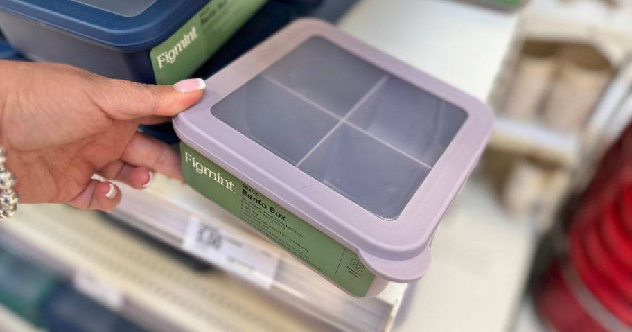 person grabbing purple bento box from store shelf