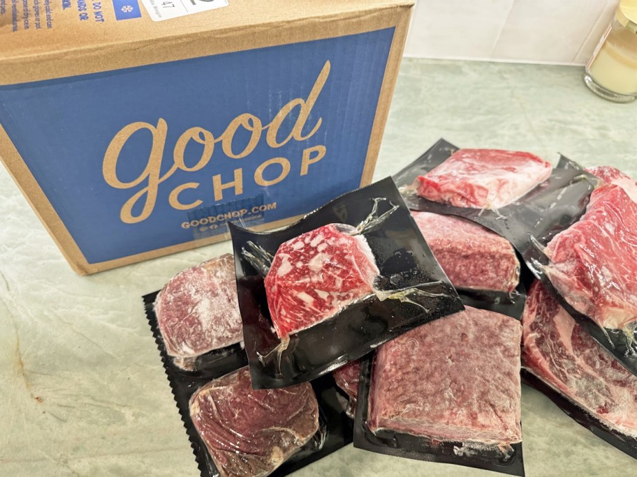 multiple packs of frozen meats in front of Good Chop shipping box