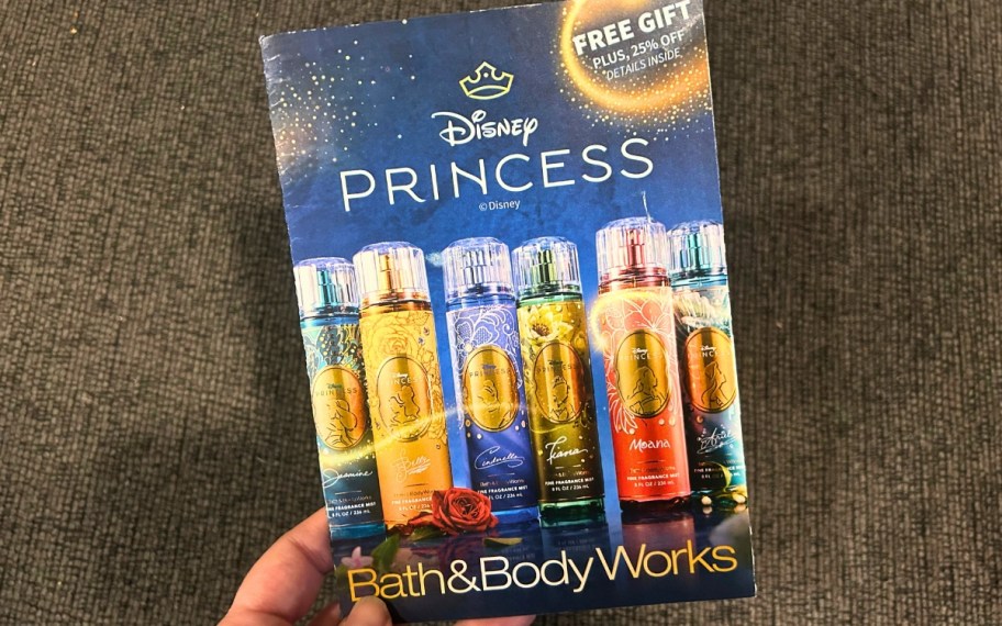 hand holding a Bath & Body Works mailer with images of the Disney Princess Collection Fragrance Mists on it