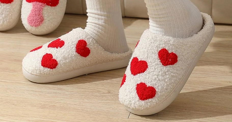 woman wearing a pair of white slippers with red hearts print