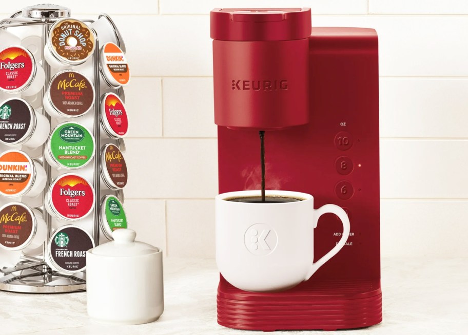 red Keurig K-Express Coffee Maker near a rack of k-cups