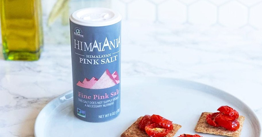 bottle of Natierra Himalania Himalayan Pink Salt on a plate with crackers and tomatoes