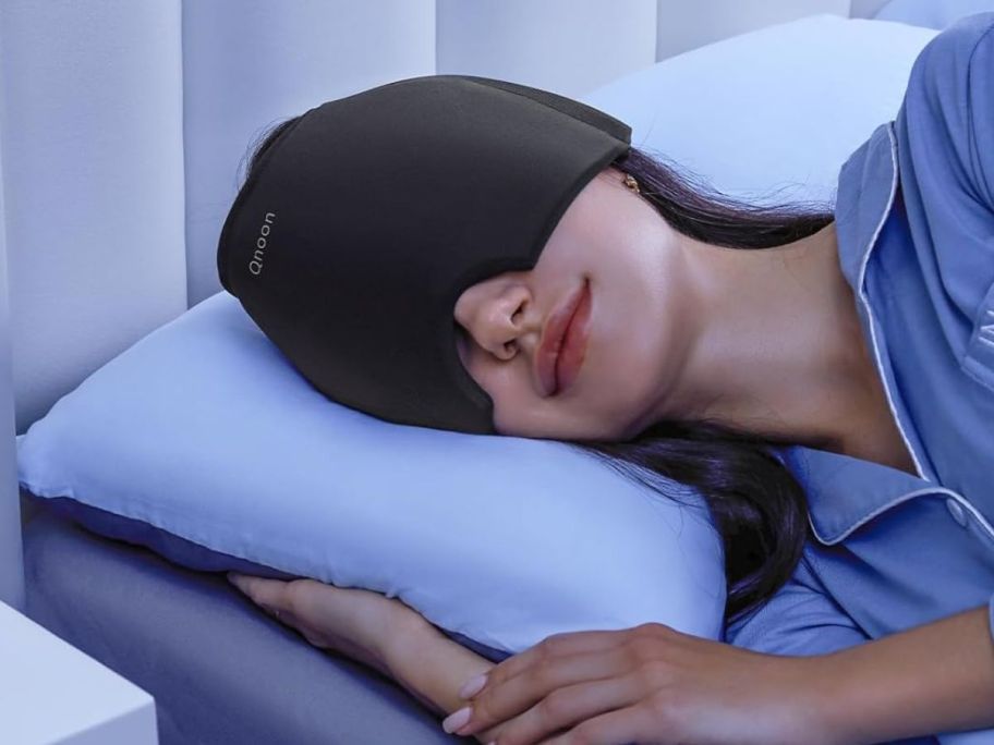 A woman sleeping with a Qnoon Migraine Headache Relief Cap on 